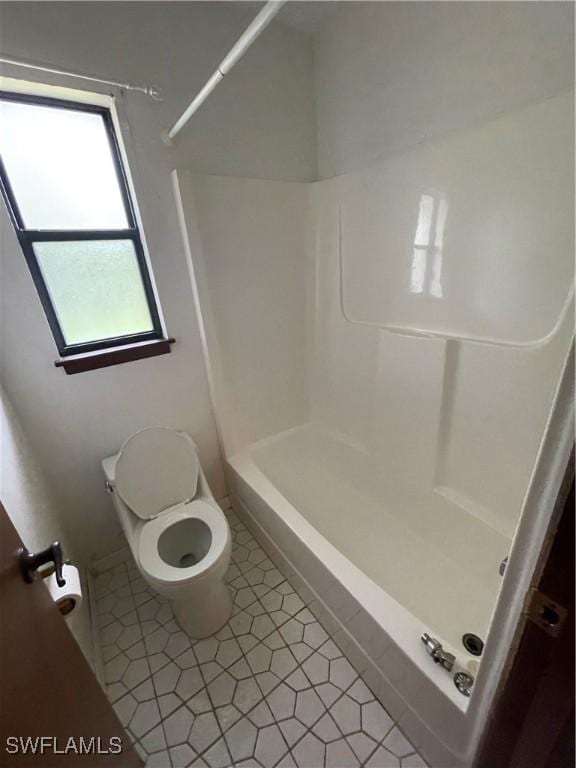 bathroom featuring shower / bathtub combination and toilet