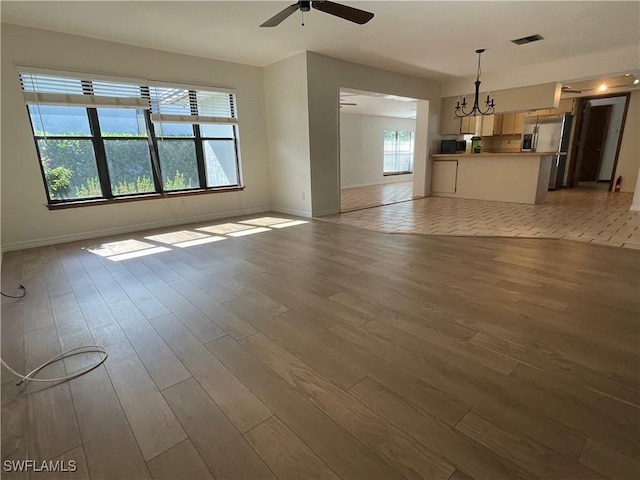 unfurnished living room featuring ceiling fan and light hardwood / wood-style flooring