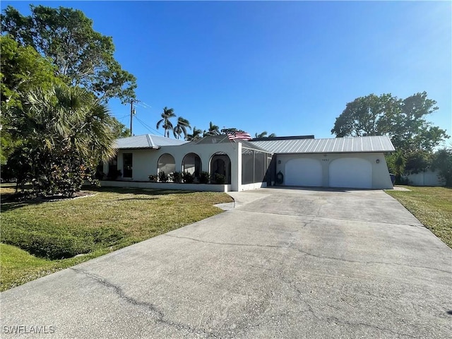 ranch-style home with driveway, stucco siding, an attached garage, and a front yard