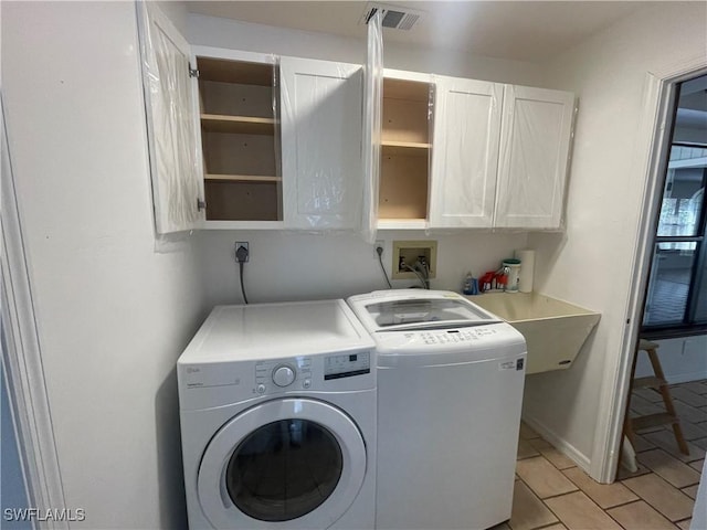 laundry area featuring cabinet space, visible vents, a sink, washer and dryer, and baseboards