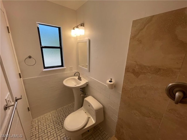 9882 Connecticut St, Bonita Springs, FL 34135 - bathroom with tile patterned floors, tile walls, a wainscoted wall, toilet, and tiled shower