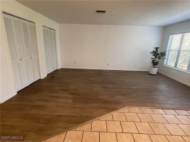 9882 Connecticut St, Bonita Springs, FL 34135 - unfurnished bedroom featuring multiple closets, baseboards, wood finished floors, and visible vents