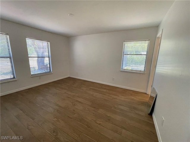 9882 Connecticut St, Bonita Springs, FL 34135 - unfurnished room with baseboards, a healthy amount of sunlight, and wood finished floors