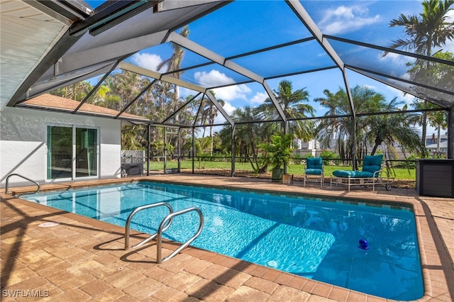 view of swimming pool with glass enclosure and a patio area