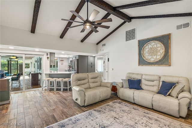 living room featuring high vaulted ceiling, hardwood / wood-style flooring, ceiling fan, and beam ceiling