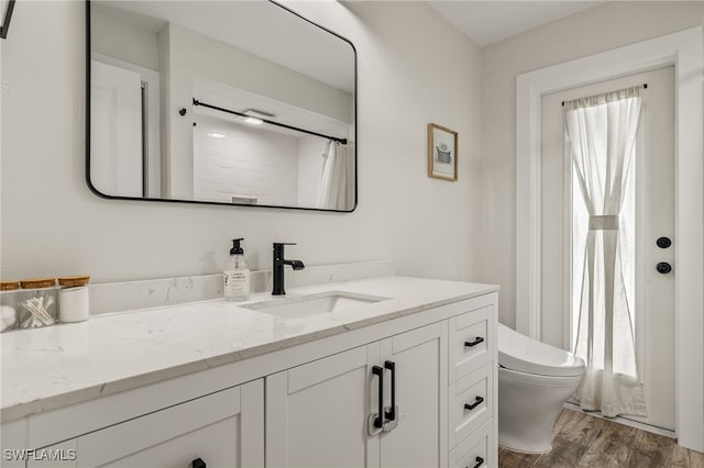 bathroom with hardwood / wood-style floors, vanity, toilet, and a shower with curtain