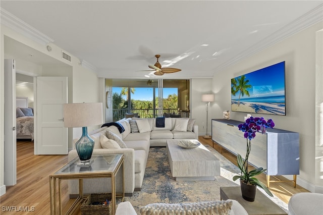 living room with ceiling fan, crown molding, and light hardwood / wood-style flooring