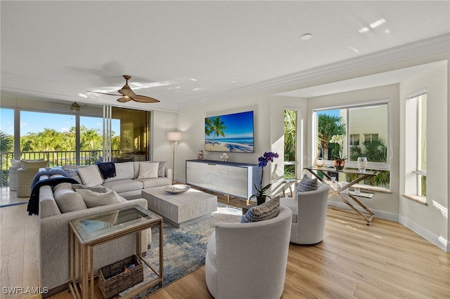 living room featuring light hardwood / wood-style flooring, ceiling fan, and crown molding