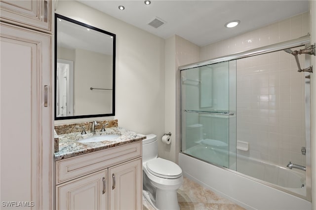 full bathroom featuring tile patterned flooring, vanity, toilet, and shower / bath combination with glass door