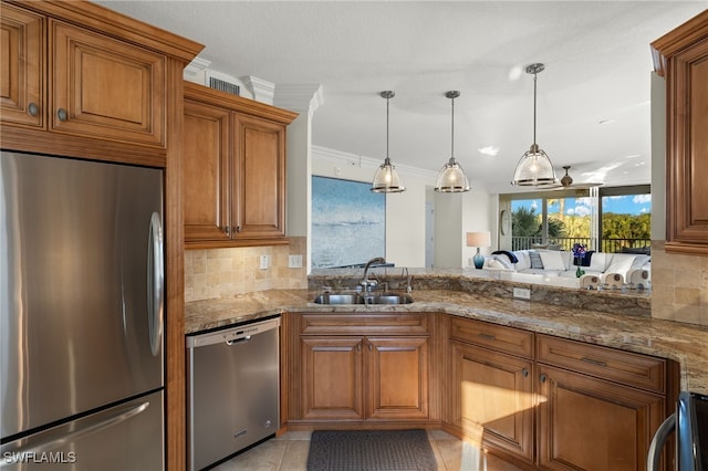 kitchen featuring decorative light fixtures, light stone counters, sink, and appliances with stainless steel finishes