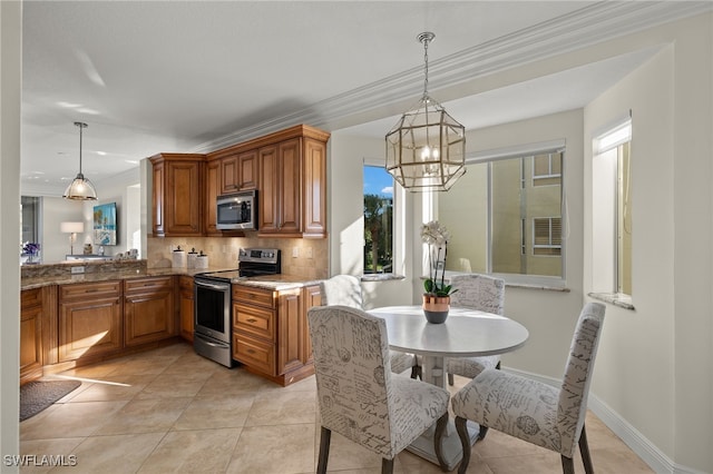 kitchen with decorative light fixtures, ornamental molding, appliances with stainless steel finishes, and tasteful backsplash