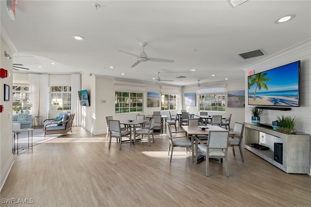 dining space featuring ceiling fan, crown molding, and light wood-type flooring