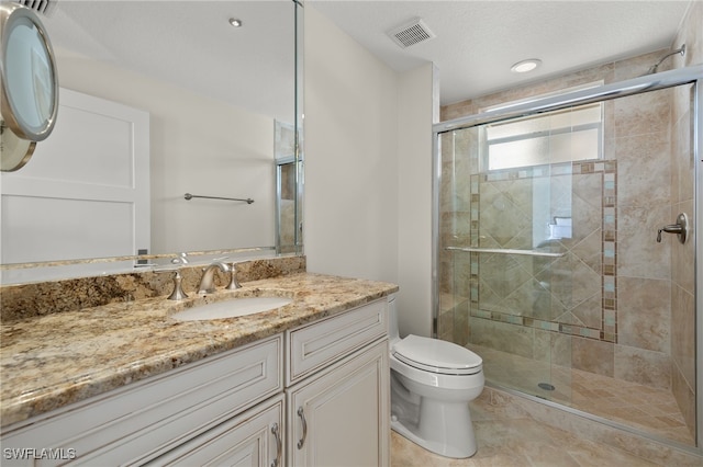 bathroom with tile patterned flooring, vanity, toilet, and walk in shower