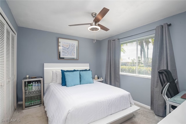 bedroom featuring light carpet, a closet, and ceiling fan