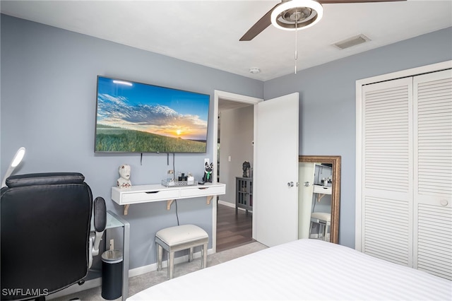 bedroom with ceiling fan, light hardwood / wood-style floors, and a closet