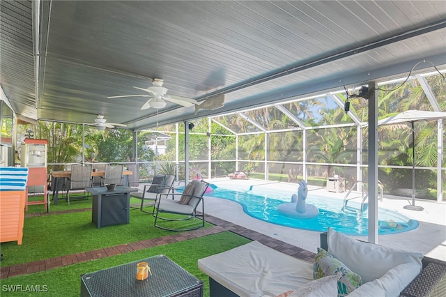 view of pool with an outdoor living space, glass enclosure, ceiling fan, a yard, and a patio