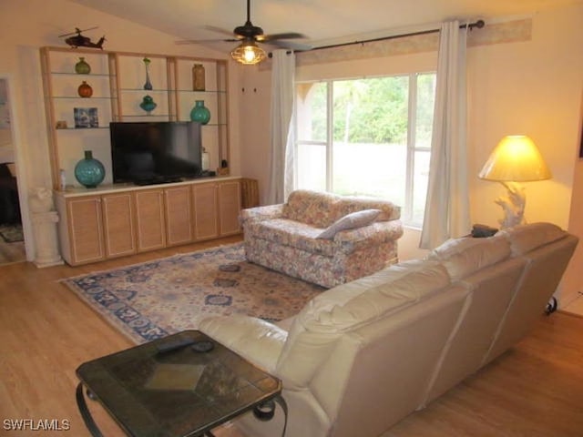 living room featuring vaulted ceiling, ceiling fan, and light hardwood / wood-style flooring