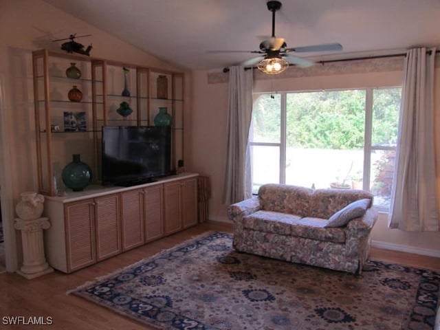 living room featuring ceiling fan, light hardwood / wood-style flooring, and lofted ceiling