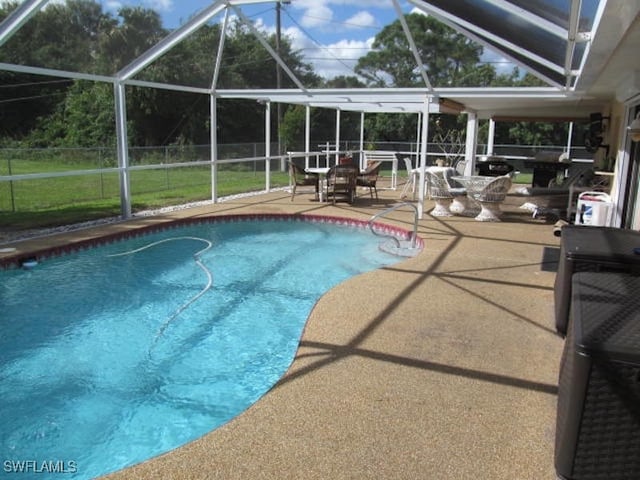 view of pool with glass enclosure and a patio area