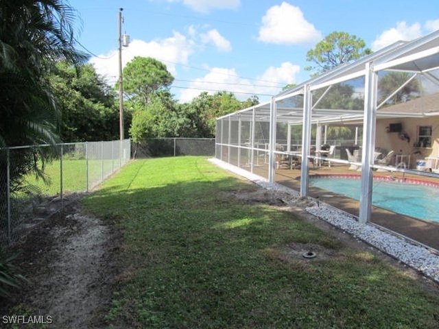 view of yard featuring glass enclosure and a fenced in pool