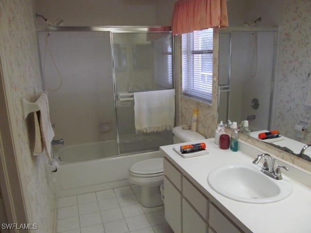 full bathroom with toilet, bath / shower combo with glass door, vanity, and tile patterned flooring