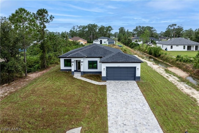 view of front of house with an attached garage, stucco siding, decorative driveway, and a front yard