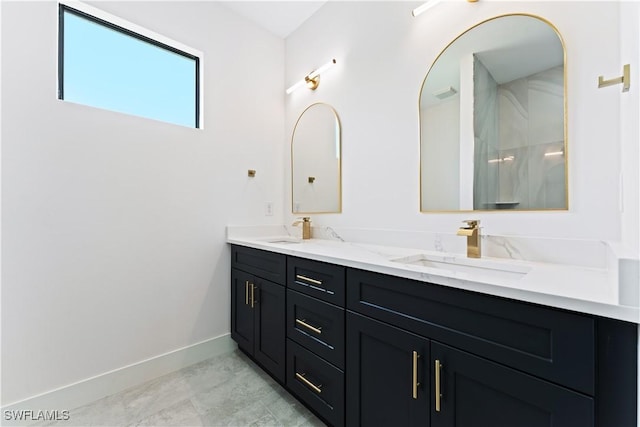 bathroom with double vanity, baseboards, and a sink