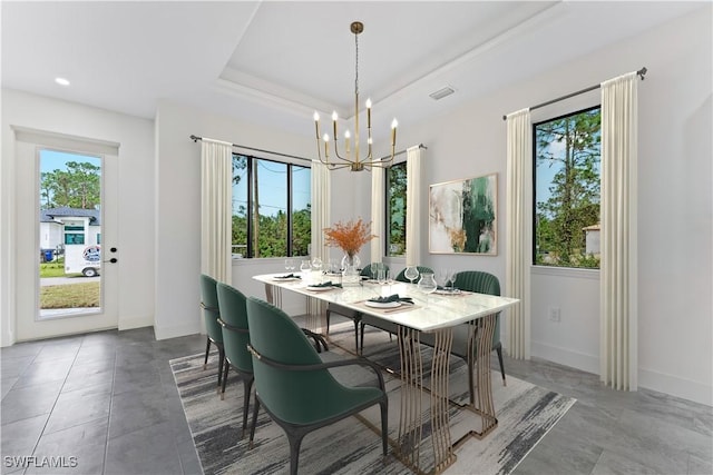 dining room with a raised ceiling, a healthy amount of sunlight, a notable chandelier, and baseboards