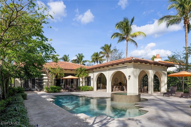 view of pool featuring a patio and an in ground hot tub