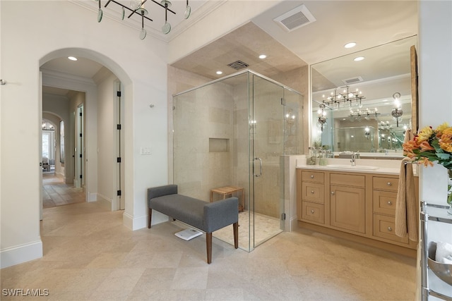 bathroom with walk in shower, vanity, and crown molding