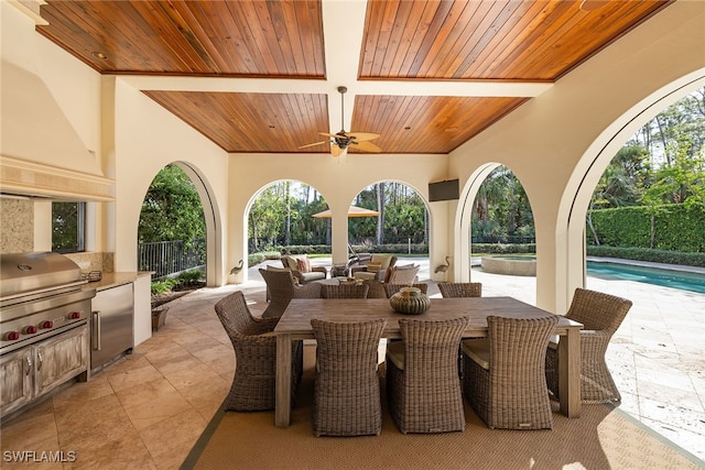 view of patio with area for grilling, an outdoor kitchen, ceiling fan, and a fenced in pool