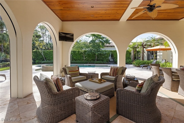 view of patio featuring ceiling fan and a swimming pool with hot tub