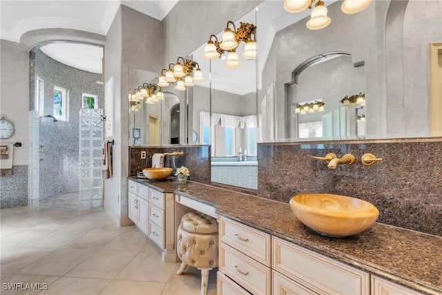 bathroom with tile patterned floors, vanity, tiled shower, and tile walls