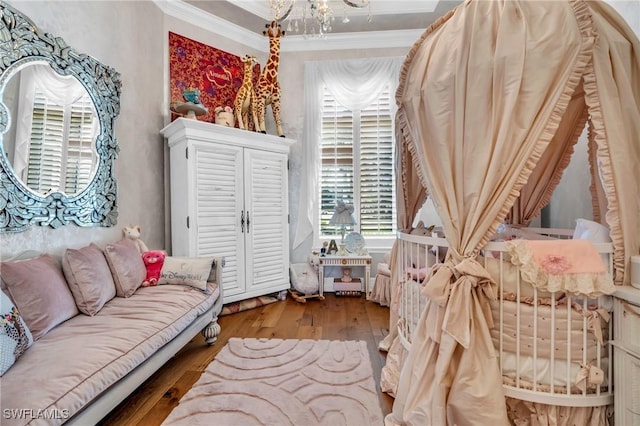 sitting room with a healthy amount of sunlight, wood-type flooring, and crown molding