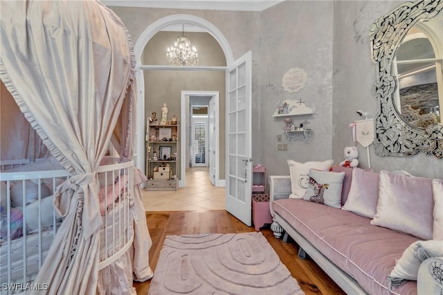 interior space with french doors, light hardwood / wood-style floors, crown molding, and a notable chandelier