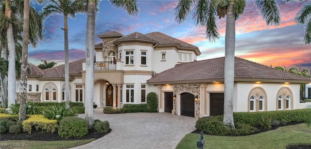 mediterranean / spanish-style home with a balcony, a garage, and a lawn