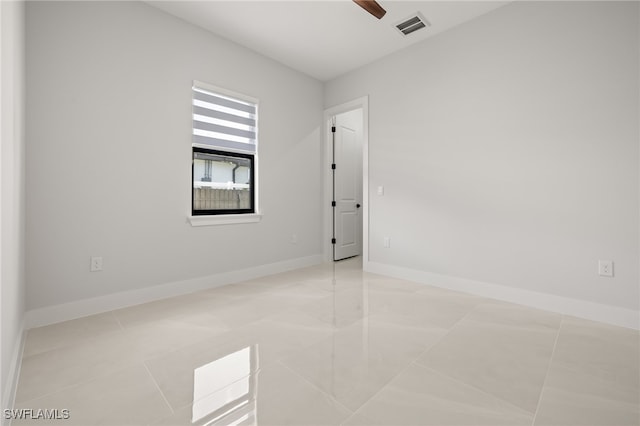 unfurnished room with ceiling fan and light tile patterned floors