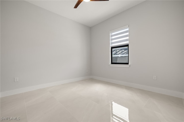 tiled empty room featuring ceiling fan