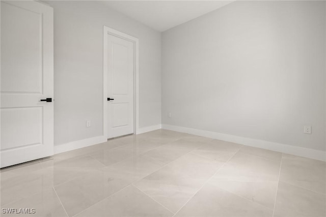 728 SW 8th Ter, Cape Coral, FL 33991 - spare room featuring baseboards and light tile patterned flooring