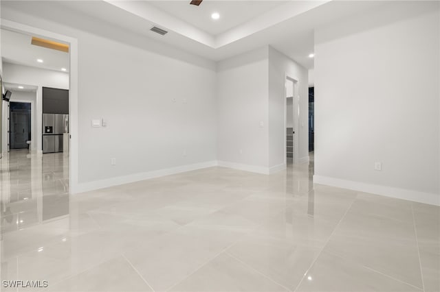 spare room featuring a barn door and light tile patterned floors