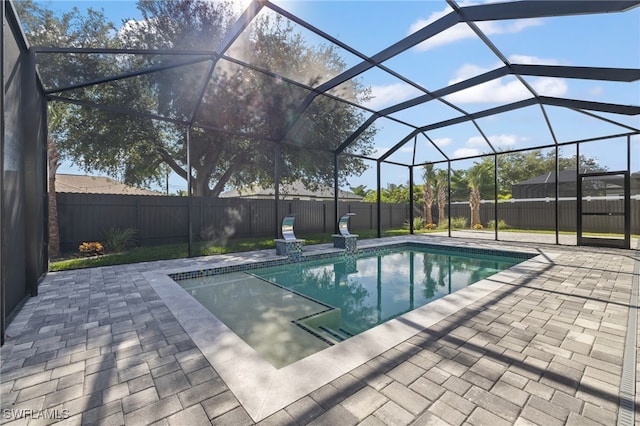 view of swimming pool featuring glass enclosure and a patio