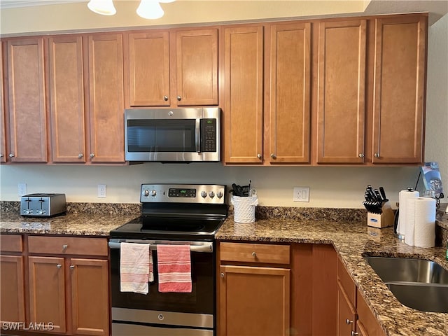 kitchen featuring appliances with stainless steel finishes and dark stone counters