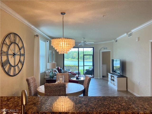 tiled dining area featuring a textured ceiling, ceiling fan with notable chandelier, and crown molding