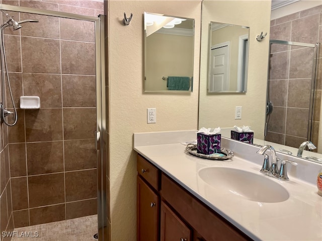 bathroom with walk in shower, vanity, and crown molding