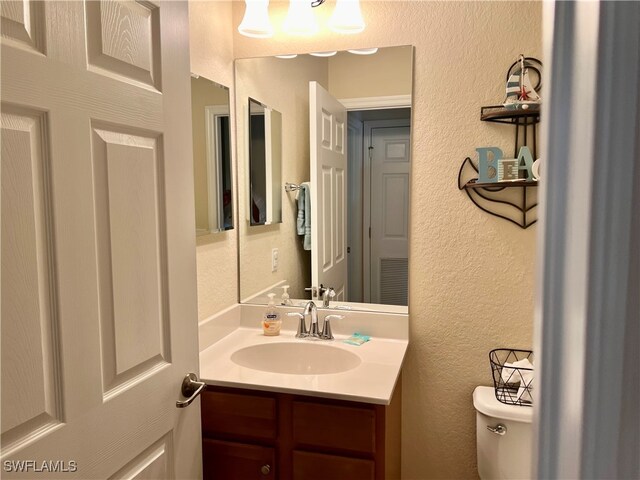 bathroom with toilet and vanity