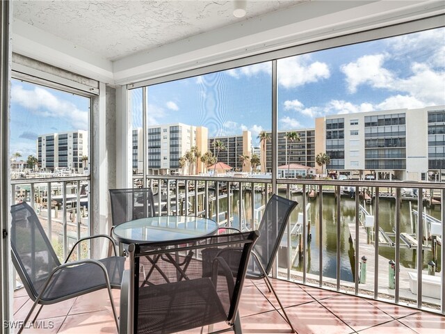 sunroom featuring a water view