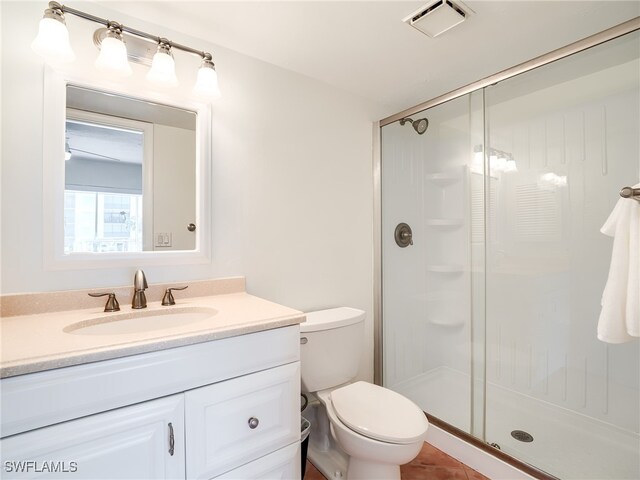 bathroom with tile patterned flooring, vanity, toilet, and a shower with door