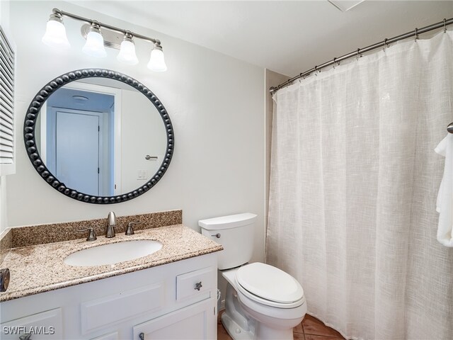 bathroom featuring tile patterned floors, vanity, a shower with shower curtain, and toilet