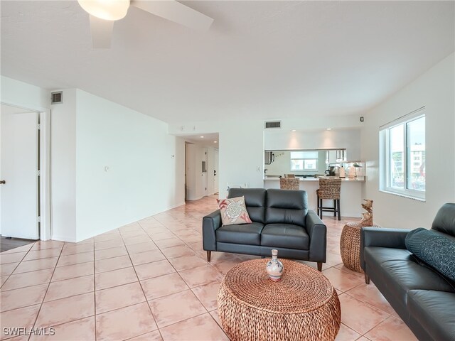 tiled living room with ceiling fan