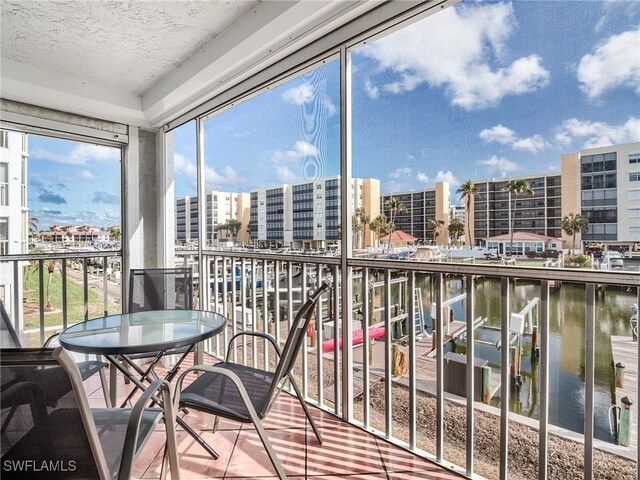 sunroom featuring a water view